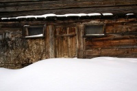 Verschneites Holzhaus am Wegesrand...